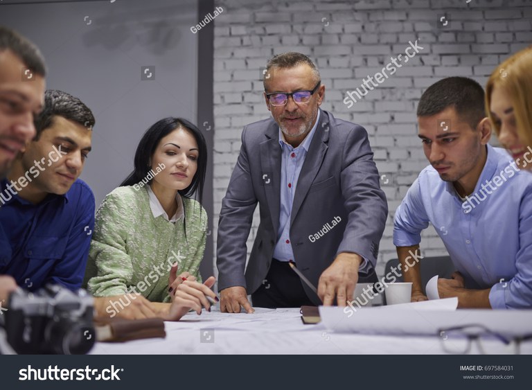 stock-photo-mature-skilled-proud-ceo-in-eyeglasses-with-team-of-male-and-female-experienced-professionals-697584031.jpg